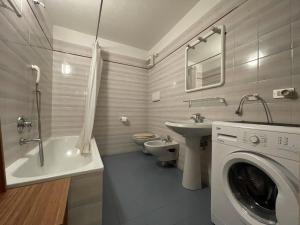 a bathroom with a washing machine and a washer at Appartamento Vadaione Est in Giustino +29 photos