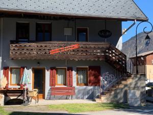 a house with red shutters and a red bench in front at Les cols in Sainte-Marie-de-Cuines