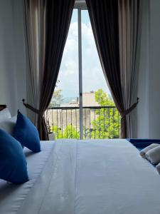 a bedroom with a bed and a large window at Kandy Alpine Breeze in Kandy