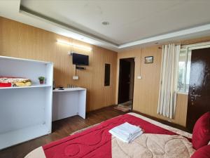 a room with a bed and a kitchen in it at 7 Hills Resort Kanatal in Kanatal