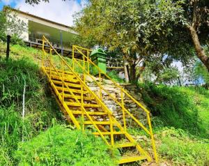 a yellow stairway leading up a hill with a building at 7 Hills Resort Kanatal in Kanatal
