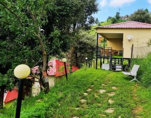 a view of a yard with a house at 7 Hills Resort Kanatal in Kanatal +2 photos