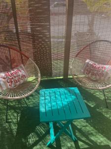a blue bench sitting next to two chairs at Chez Permal in Saint-Pierre +2 photos