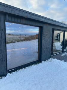 a building with a large window in the snow at Le Garage de Charly Piscine, Sauna & Gym - Aux rêves des Champs in Éghezée