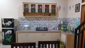 a kitchen with a counter top and a refrigerator at Villa 4 Kamar Tidur Dengan Kolam Renang Pribadi in Puncak