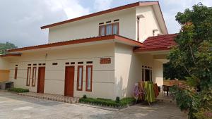 a white house with a red roof at Villa 4 Kamar Tidur Dengan Kolam Renang Pribadi in Puncak