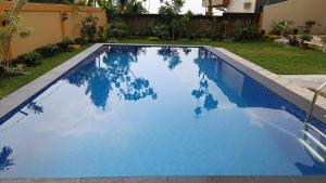 a swimming pool with blue water in a yard at Villa 4 Kamar Tidur Dengan Kolam Renang Pribadi in Puncak