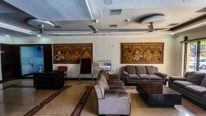 a living room with couches and a table at Hotel White City in North Paravur