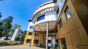 a large building with a round building at Hotel White City in North Paravur