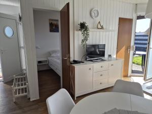 a living room with a television and a bedroom at Feriengarten Dahme W 20 in Dahme
