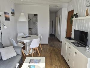 a living room with a couch and a tv and a table at Feriengarten Dahme W 20 in Dahme