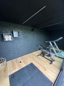 a room with a gym with a treadmill at Le Garage de Charly Piscine, Sauna & Gym - Aux rêves des Champs in Éghezée
