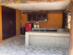 a kitchen with a counter and a red refrigerator at ไร่ภูตะวัน in Ban Muang Ton Mamuang