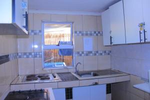 a small kitchen with a sink and a window at Inspan Home & Lodge in Bellville South