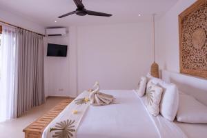 a bedroom with a bed and a ceiling fan at Bukit Adi in Amed