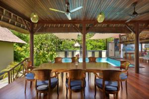 a dining room with a table and chairs and a pool at Gecko Villa & Bungalows in Nusa Lembongan