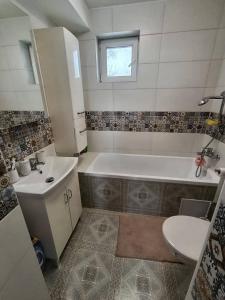 a bathroom with a tub and a sink and a toilet at Dům u Skašků - Žabeň in Žabeň