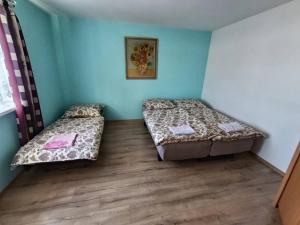 two beds in a room with blue walls at Dům u Skašků - Žabeň in Žabeň