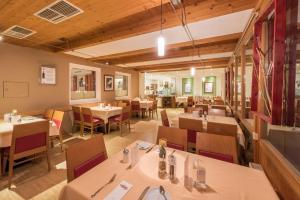 a dining room with tables and chairs and tablesktop at Austria Classic Hotel Hölle in Salzburg