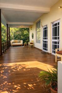 an open porch with wooden flooring and a living room at Yugm Homes Rishikesh in Narendranagar