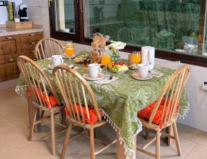 a dining room table with a green table cloth with food on it at Casa PREGONDA in Isla