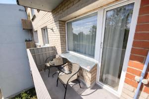 a patio with a table and chairs on a balcony at ZB Apartment with Free Private Parking in Rēzekne
