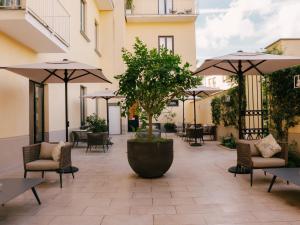 a patio with chairs and tables and umbrellas at Unconventional Sorrento Coast in Sant'Agnello +97 photos