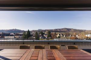 a wooden table with chairs and a large window at Hotel Alte Post Südsteiermark in Leibnitz