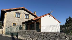 a stone house with a gate and a stone wall at Casa PREGONDA in Isla