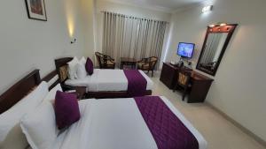 a hotel room with two beds and a television at Hotel White City in North Paravur +88 photos