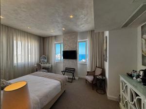 ein Hotelzimmer mit Bett und Fernseher in der Unterkunft Osborne Hotel in Valletta