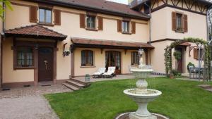 a large house with a fountain in the yard at La demeure Flieg in Cernay