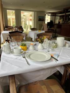 a table with white plates and glasses on it at Pension Störtebeker in Prerow