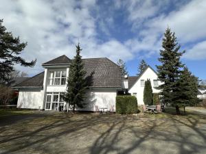 a white house with trees in front of it at Pension Störtebeker in Prerow