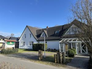 a white house with a sign in front of it at Pension Störtebeker in Prerow +6 photos