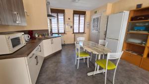 a kitchen with a table and chairs and a refrigerator at La demeure Flieg in Cernay