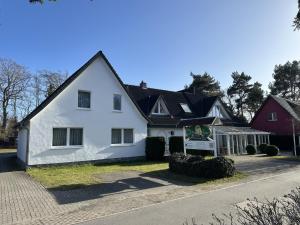 a white house with a black roof at Pension Störtebeker in Prerow
