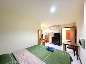 a bedroom with a bed and a table and a kitchen at Bambus Motel in Jomtien Beach
