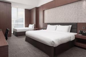 a large bedroom with two beds and a large window at Vanburgh Hotel Guangzhou in Guangzhou
