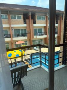 a balcony with a view of a pool and a hotel at Kata Kata Stay in Kata Beach