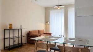 a living room with a glass table and chairs at Cocon de Charme - T2 sur Place d'Armes in Valenciennes +10 photos