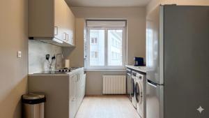 a small kitchen with a sink and a refrigerator at Cocon de Charme - T2 sur Place d'Armes in Valenciennes