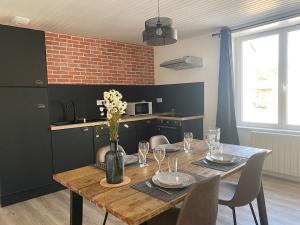 a dining room table with a vase of flowers on it at La Factory Saint Aignan in Saint-Aignan