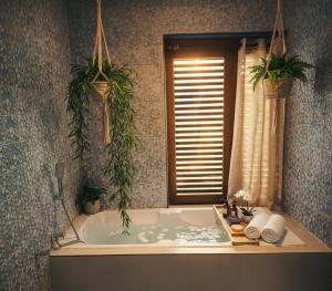 a bathroom with a bath tub with two plants at EKAM in Agonda +54 photos