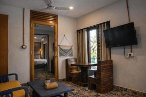 a living room with a table and a television at EKAM in Agonda