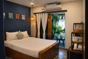 a bedroom with a large bed with a window at EKAM in Agonda