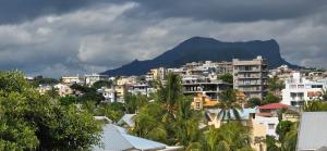 a city with buildings and a mountain in the background at Le Verger Sur Mer in Flic-en-Flac
