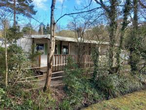 a house with a porch in the woods at Mobil-home Riviera in Vaudreuille