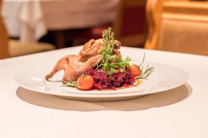 a chicken on a plate on a table at Austria Classic Hotel Hölle in Salzburg