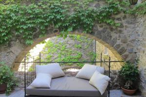 a couch sitting in front of a stone wall with ivy at Château de Madières - Châteauzen in Rogues
